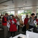 Landsindsamling 2016: Der var travlt i Røde Kors butikken, da ruterne skulle fordeles til indsamlerne. Yderst til venstre diskuterer tidligere lokalafdelingsformand, nuværende vicepræsident i Røde Kors Danmark, Svend Bak-Jensen en rute med en indsamler. Yderst til højre er indsamlingskoordinator og kasserer i Røde Kors Michael Rolf Jacobsen i fuld gang med at sende indsamlerne afsted på deres ruter